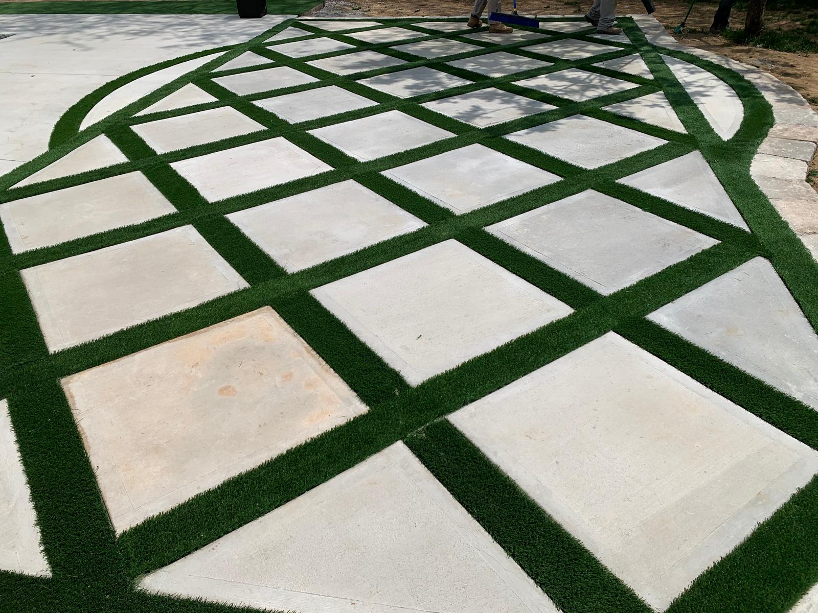 Diamond-pattern concrete pavers with turf inlays after installation