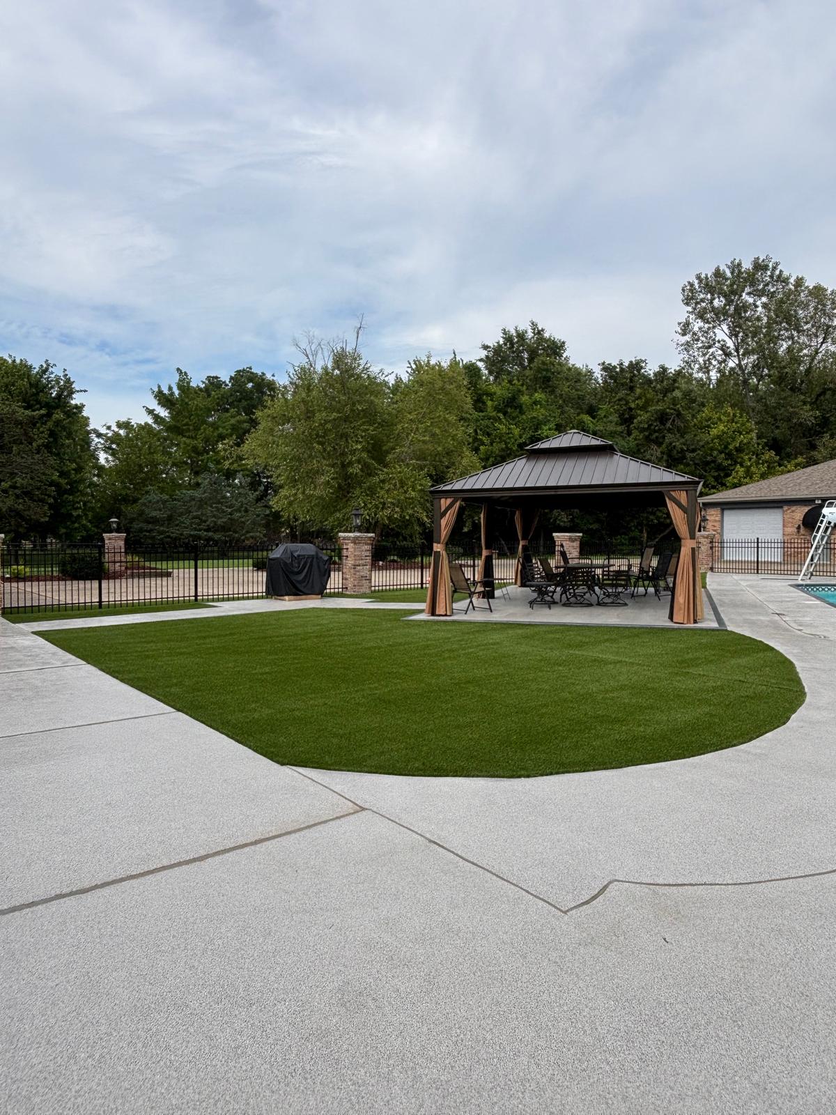 Artificial turf lawn between patio and pool area