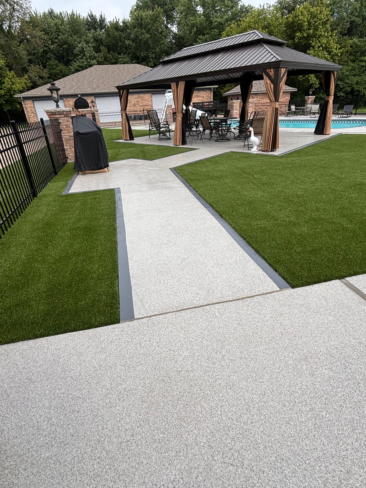 Finished artificial turf area along fence and walkway