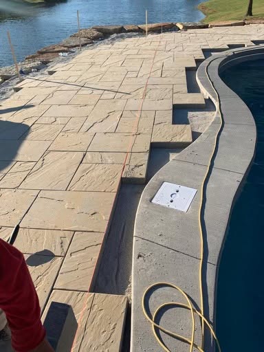Stone patio edge following the curve of the pool coping